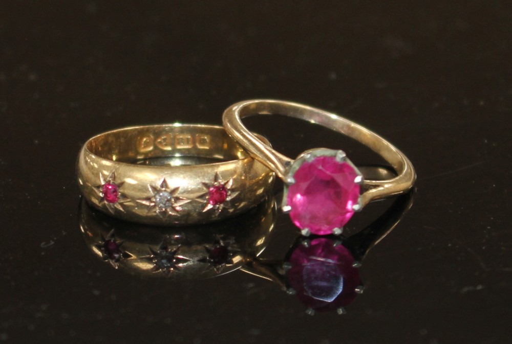 An early 20th century 18ct gold and gypsy set ruby and diamond three stone ring and one other ring.